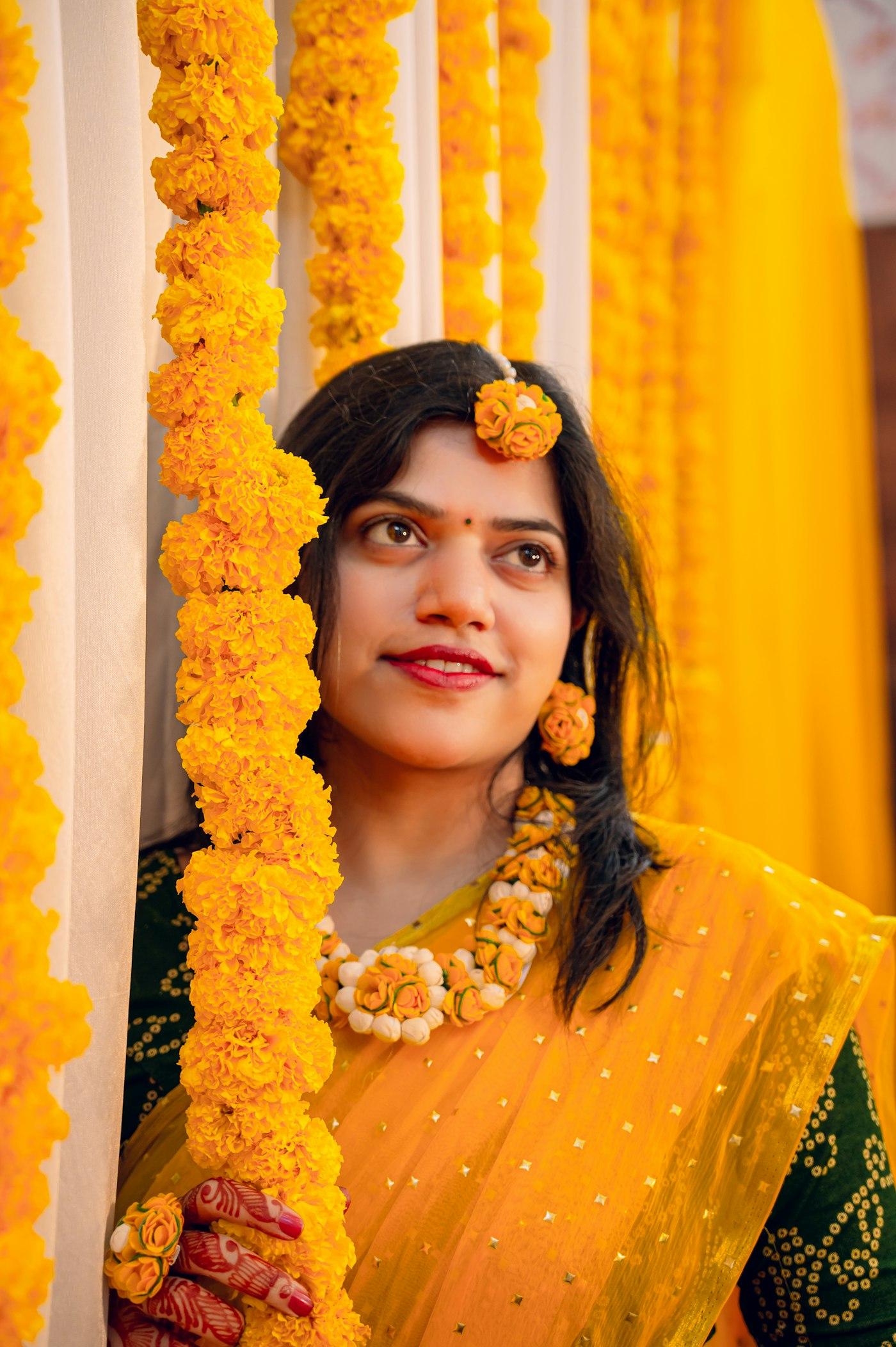 Marigold garlands hung as a backdrop for a haldi ceremony